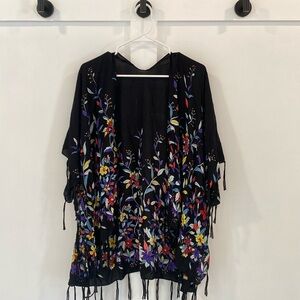 Black kimono with bright colored floral pattern and tassels